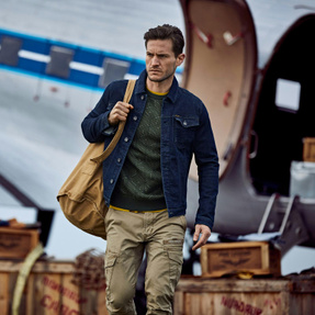 Man with blue denim jacket and green cargo pants